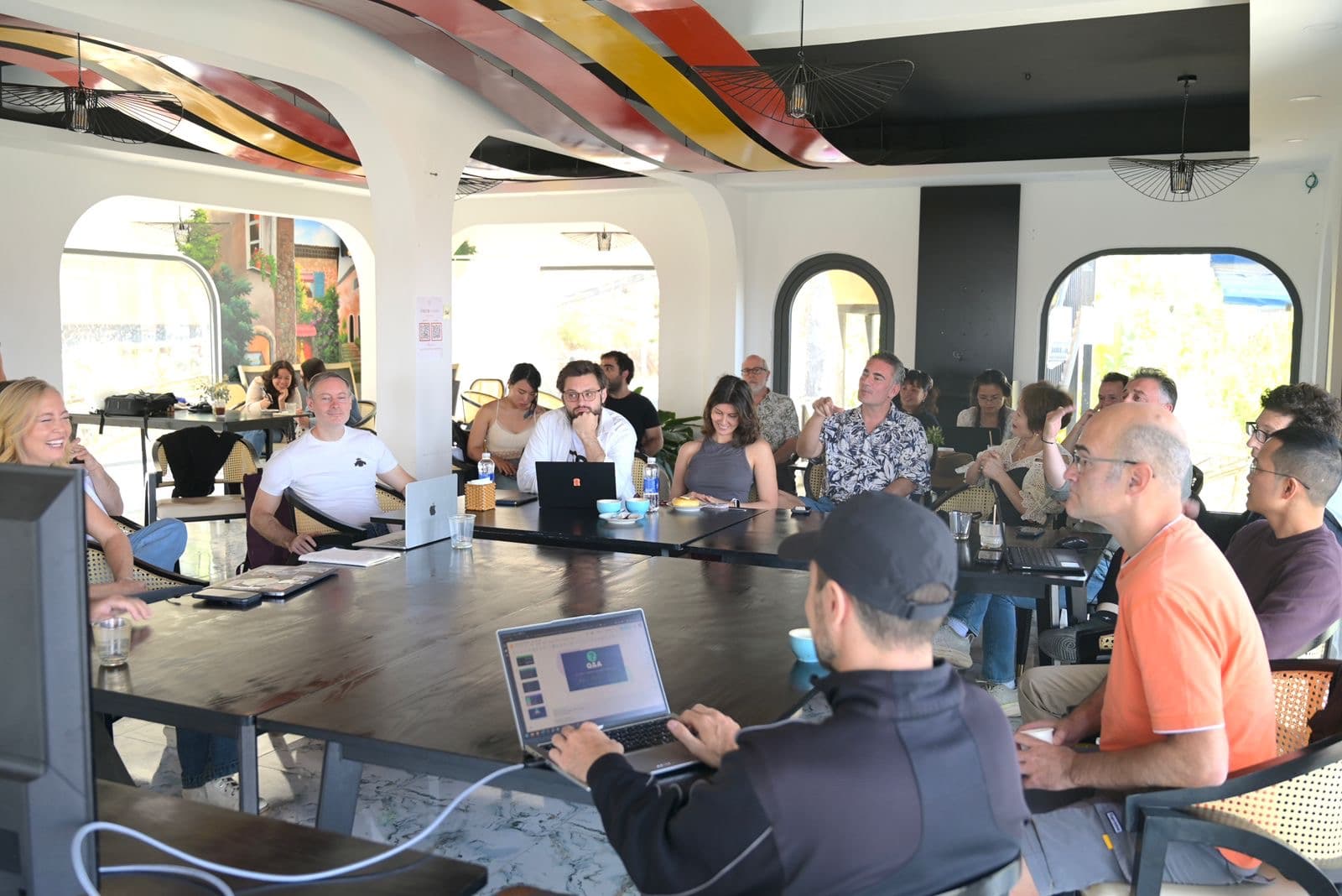 People gathered around a large table with laptops